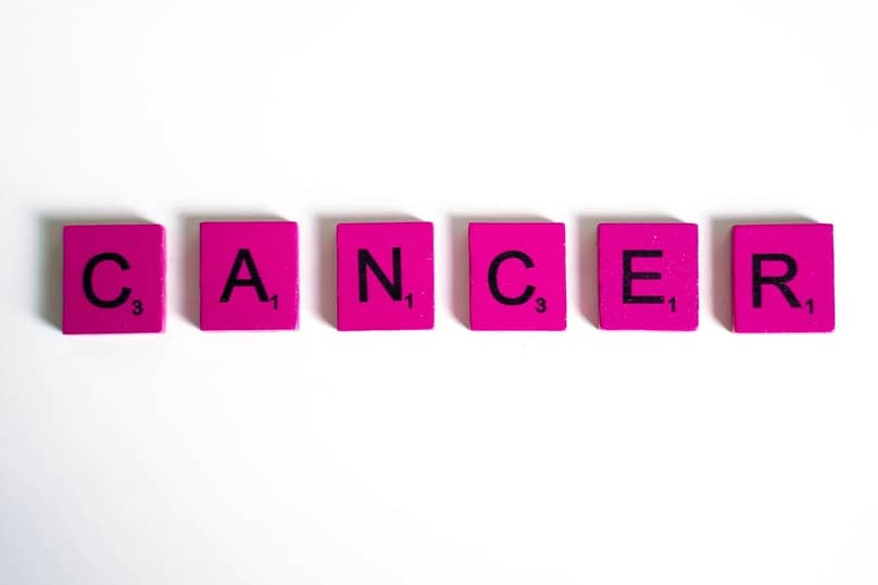cancer word spelled on scrabble tiles
